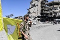 シリア北部ラッカで、クルド人とアラブ人の合同部隊「シリア民主軍」の旗を手にする隊員（2017年10月17日撮影）。(c)AFP/BULENT KILIC