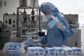中国・北京の医療品メーカーで、防護服を着てマスク製造に当たる従業員（2020年4月24日撮影、資料写真）。(c)WANG ZHAO / AFP