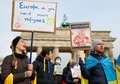 ドイツ・ベルリンで開催されたウクライナ侵攻に対する抗議デモで、ロシアのウラジーミル・プーチン大統領をアドルフ・ヒトラーになぞらえたプラカードを掲げる人（2022年2月27日撮影）。(c)Odd ANDERSEN / AFP