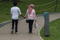 マレーシア・クアラルンプールの公園で、手をつないで歩くイスラム教徒のカップル（2015年10月5日撮影）。 (c)AFP/MOHD RASFAN