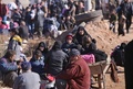 シリア北部アレッポで、戦闘を逃れ、政府軍側部隊が管理する検問所に集まる住民（2016年12月8日撮影）。(c)AFP/Youssef KARWASHAN
