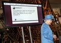 訪問先のロンドン（London）の科学博物館（Science Museum）で、初めてマイクロブログのツイッター（Twitter）にメッセージを投稿した英国のエリザベス女王（Queen Elizabeth II）。後ろのスクリーンに女王のツイートが表示されている（2014年10月24日撮影）。(c)AFP/RICHARD POHLE
