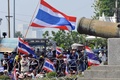 タイの首都バンコク（Bangkok）で、国防省の施設前の通りを封鎖しタイ国旗を振る反政府デモの参加者たち（2014年1月22日撮影）。(c)AFP