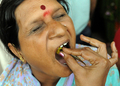 インド・ハイデラバード（Hyderabad）で8日、Bathini Goudさんによる「魚療法（Fish Medicine）」が行われ、投薬を受けるために全国から数千人が集まった。「魚療法」はぜんそくなどの気管支系疾患に効くとして、同国南部に暮らすこの一家が158年前から代々行っている療法で、薬草から作られた秘伝の薬を生きた魚にくわえさせ、順番に患者の口の中に落としていくというもの。投薬は6月のモンスーン到来とともに訪れる縁起の良い日「Mrigasira Karti」に行われる。写真は、患者に投薬するBathini Goudさんの家族（右、2009年6月8日撮影）。(c)AFP/Noah SEELAM