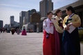 韓国の首都ソウル中心部にある光化門広場でのパレードに参加する韓服姿の女性たち（2015年9月24日撮影）。(c)AFP/Ed Jones
