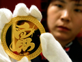 中国北部陝西省（%%Shaanxi%%）西安（%%Xian%%）市内の宝石商で、金製の装飾品を展示する店員（2008年3月30日撮影）。(c)AFP