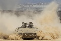 パレスチナ自治区ガザ（Gaza）地区との境界付近を移動するイスラエル軍の兵員輸送装甲車（2014年7月25日撮影）。(c)AFP/JACK GUEZ