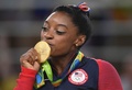 リオデジャネイロ五輪、体操女子種目別ゆか。表彰式でメダルにキスをするシモーネ・バイルス（2016年8月16日撮影）。(c)AFP/Toshifumi KITAMURA