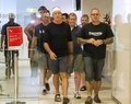 豪クイーンズランド（Queensland）州ケアンズ（Cairns）の空港に到着した、パプアニューギニアでトレッキング中に襲撃された観光客のニック・ベネット（Nick Bennet）さん（前列左）とピーター・スティーブンス（Peter Stevens）さん（同中央、2013年9月12日撮影）。(c)AFP/