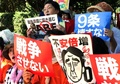 東京の国会議事堂前で、衆議院平和安全法制特別委員会が可決した安全保障関連法案に抗議するデモに参加した市民団体の女性メンバーら（2015年7月15日撮影）。(c)AFP/Yoshikazu TSUNO