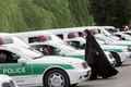 2007年7月23日、パトカーの間を歩く女性警官。(c)AFP PHOTO/Behrouz MEHRI