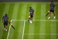 テニス、ウィンブルドン選手権、男子シングルス1回戦。芝を乾かすスタッフ（2023年7月3日撮影）。(c)Daniel LEAL / AFP
