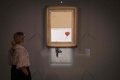 ロンドンの競売会社サザビーズ競売所で公開されたバンクシーの作品「Love is in the Bin（愛はごみ箱の中に）」（2021年10月8日撮影）。(c)Tolga Akmen / AFP