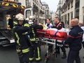 銃撃のあった仏パリ（Paris）にある風刺週刊紙シャルリー・エブド（Charlie Hebdo）の本社の外で、負傷者を搬送する消防隊員（2015年1月7日撮影）。(c)AFP/PHILIPPE DUPEYRAT
