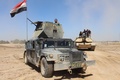 イスラム過激派組織「イスラム国」が支配していた地域を政府側が奪還した後、イラク・ヒートに近いアルマムラ村を移動するイラクの対テロ部隊の装甲車（左、2016年4月2日撮影）。(c)AFP/MOADH AL-DULAIMI