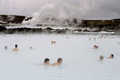 写真はアイスランドの首都レイキャビク（Reykjavik）郊外にある温泉｢ブルーラグーン（Blue Lagoon）｣を楽しむ観光客。ブルーラグーンは水の色が青と緑であることから、この名で呼ばれている。健康効果もうたわれている（2009年4月26日撮影）。(c)AFP/OLIVIER MORIN