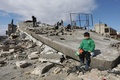 シリア・アザズで、大地震のために倒壊した建物の上に座る少年（2023年2月7日撮影）。(c)Bakr ALKASEM / AFP