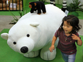 2007年7月21日、千葉の東武百貨店船橋店「船橋タオル動物園」で、タオルで作られたホッキョクグマのぬいぐるみとそばで遊ぶ女の子。(c)AFP/TOSHIFUMI KITAMURA
