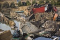 中国東部山東（Shandong）省青島（Qingdao）で、石油パイプラインの爆発で裂けた道路と横転した車両（2013年11月22日撮影）。(c)AFP
