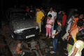 インド北東部シリグリ（Siliguri）で、マグニチュード（M）6.9の地震で倒壊した壁と損傷した車を見つめる住民たち（2011年9月18日撮影）。(c)AFP/DIPTENDU DUTTA