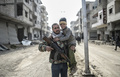 イスラム教スンニ派の過激派組織「イスラム国（IS）」からクルド人部隊が奪還したシリア北部の要衝の町アインアルアラブ（クルド名：コバニ）で会ったクルド人戦闘員の親子（2015年2月28日撮影）。(c)AFP/BULENT KILIC
