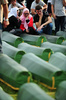 ボスニア・ヘルツェゴビナ東部スレブレニツァ（Srebrenica）近くの村で、1995年のスレブレニツァ虐殺で死亡した親族のひつぎを前に嘆き悲しむ女性ら（2013年7月10日撮影）。(c)AFP/ELVIS BARUKCIC