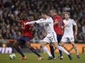サッカースペイン国王杯（Copa del Rey 2013-14）5回戦、レアル・マドリード（Real Madrid）対オサスナ（CA Osasuna）第1戦。オサスナのフランシスコ・プニャル（Francisco &quot;Patxi&quot; Punal、左）らとボールを競るレアル・マドリードのクリスティアーノ・ロナウド（Cristiano Ronaldo、中央左、2014年1月9日撮影）。(c)AFP/DANI POZO
