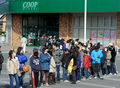 宮城県のスーパーの列に並ぶ人びと（2011年3月13日撮影）。(c)AFP/MIKE CLARKE