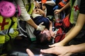 香港空港で、デモ隊から中国のスパイと疑われ負傷した男性を搬送する救急隊員（2019年8月14日撮影）。(c)Anthony WALLACE / AFP