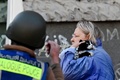 ウクライナの首都キーウで、ロシア軍の攻撃を受け猫を抱いて避難する女性（2022年10月10日撮影）。(c)SERGEI CHUZAVKOV / AFP