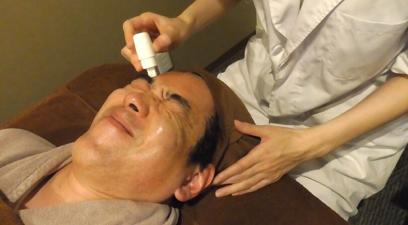 マイクロニードルにより施術を受け、顔をゆがめる米村さん(c)KOREA WAVE