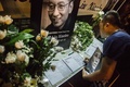 劉暁波氏の死去を受け、中国・香港の中央政府駐香港連絡弁公室に設けられた記帳台に書き込む人（2017年7月13日撮影）。(c)AFP/Isaac Lawrence