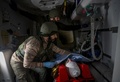 ウクライナ東部ドネツク州バフムート近郊で、負傷したウクライナ兵を応急処置用の移動病院から避難させるボランティアの救急隊員（2022年11月28日撮影）。(c)ANATOLII STEPANOV / AFP