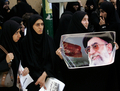 写真は同日、テヘラン（Tehran）の大学前で行われたデモで、故アヤトラ・ホメイニ師（%%Ayatollah Khomeini%%）の肖像画を手にする民兵組織バシジ（%%Basij%%）の学生メンバー。(c)AFP/BEHROUZ MEHRI