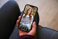 がん治療を受けていることを公表したキャサリン英皇太子妃の動画を見る女性。英イングランド・マーズデンで（2024年3月22日撮影）。(c)Oli SCARFF / AFP