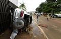 コートジボワールのアビジャンで、横転した車のそばを歩く人々（2018年6月19日撮影）。(c)AFP PHOTO / Sia KAMBOU