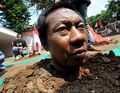 インドネシアの首都ジャカルタ（Jakarta）で、体を地中に埋めて大統領選の結果に抗議するメガワティ・スカルノプトリ（Megawati Sukarnoputri）前大統領の支持者（2009年8月6日撮影）。(c)AFP/Bay ISMOYO