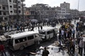 シリア中部ホムスで、2台の自動車爆弾が爆発した現場に集まった人々（2016年2月21日撮影）。(c)AFP