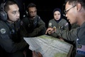 消息を絶ったマレーシア航空（Malaysia Airlines）機の捜索に参加し、マラッカ海峡（Strait of Malacca）上空を飛行するマレーシア空軍機内で同僚と打ち合わせをするマレーシア空軍の航法士（右、2014年3月14日撮影）。(c)AFP/MOHD RASFAN