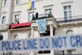 英ロンドン中心部で、ロシア人富豪オレグ・デリパスカ氏に関連する邸宅から横断幕を掲げる活動家グループ（2022年3月14日撮影）。(c)Tolga Akmen / AFP