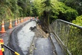 暴風雨で損壊した道路。ニュージーランド北島のウェストオークランド郊外で（2023年2月13日撮影）。(c)Diego OPATOWSKI / AFP