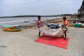 インド西部に大型サイクロンが接近する中、ムンバイ近郊の漁村で網を運ぶ漁師たち（2021年5月16日撮影）。(c)Indranil MUKHERJEE / AFP