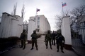ウクライナ南部クリミア（Crimea）半島のNovoozerneで、ウクライナ海軍基地を制圧した後、入り口を警備するロシア兵とみられる部隊（2014年3月19日撮影）。(c)AFP/Filippo MONTEFORTE