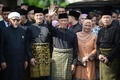 マレーシア・クアラルンプールで、首相就任宣誓式を控える中、自宅前で手を振るムヒディン・ヤシン次期首相（中央）。情報省提供（2020年3月1日撮影、公開）。(c)AFP PHOTO / MALAYSIA&apos;S DEPARTMENT OF INFORMATION / NAZRI RAPAAI
