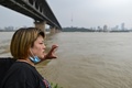 中国・湖北省武漢で、水位の上がった長江を見る住民（2020年7月14日撮影）。(c)Hector RETAMAL / AFP