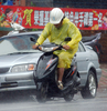 2007年9月18日、台風12号が接近する台湾の基隆（Keelung）北部で土砂降りの中、オートバイを運転する住民。(c)AFP/PATRICK LIN