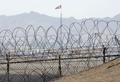韓国と北朝鮮を隔てる南北軍事境界線に沿って設けられている非武装地帯の向こうに見える北朝鮮国旗（2012年3月25日撮影、資料写真）。(c)AFP/SAUL LOEB