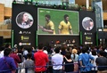 都内で行われた家庭用ゲーム機「プレイステーション4（PlayStation 4、PS4）」用サッカーゲーム「FIFA 14  2014 FIFA World Cup Brazil  Limited Pack」の発売イベントで、大型スクリーンに映ったゲーム画面を眺めるサッカーファンら（2014年6月4日撮影）。(c)AFP/Yoshikazu TSUNO