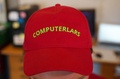 デンマークの新政党「人工党」を立ち上げたアーティスト集団「コンピューター・ラース」のメンバー、アスケー・ブリュール・スタウニス氏がかぶっていたロゴ入りキャップ。デンマーク、オーフスで（2022年8月3日撮影）。(c)James BROOKS / AFP