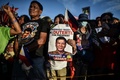 フィリピン・マニラで、大統領選の有力候補のダバオ市長、ロドリゴ・ドゥテルテ氏の顔写真を掲げた支持者ら（2016年5月7日撮影）。(c)AFP/MOHD RASFAN